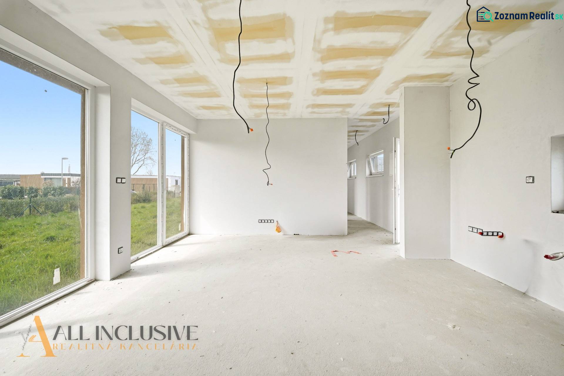 A spacious cottage with white walls and large windows, and a floor with a wooden decor.