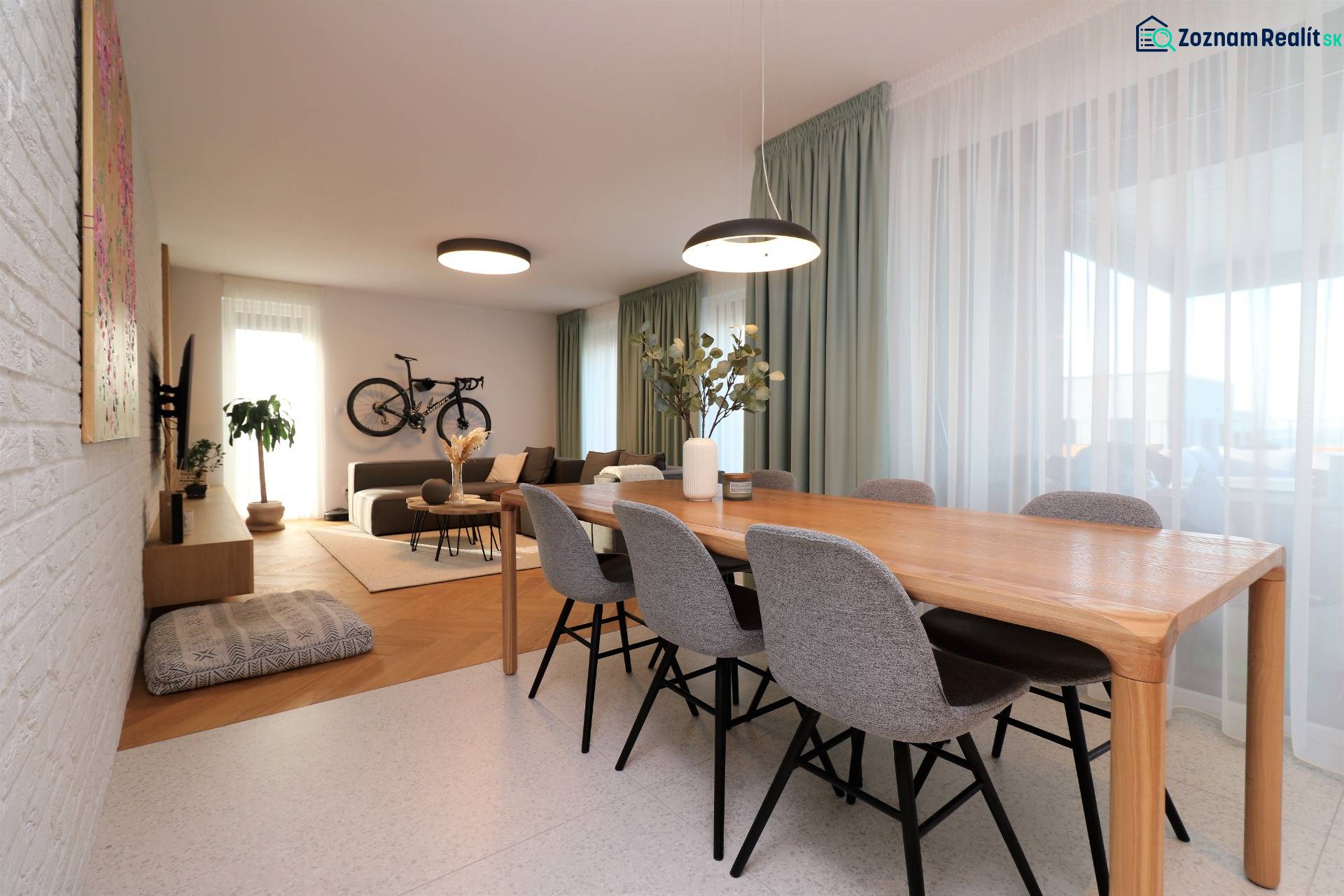 Dining table and living room in a 4-room apartment with a bicycle on the wall.