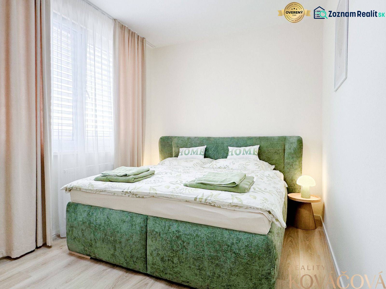 Bedroom in a 3-room apartment with a bed in green upholstery and a floor with a wooden decor.