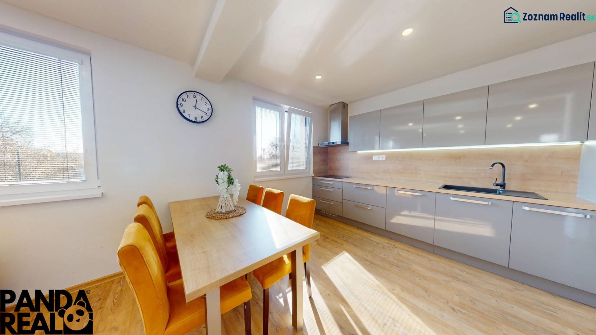 A kitchen in a family house with a wooden decor floor and yellow chairs.