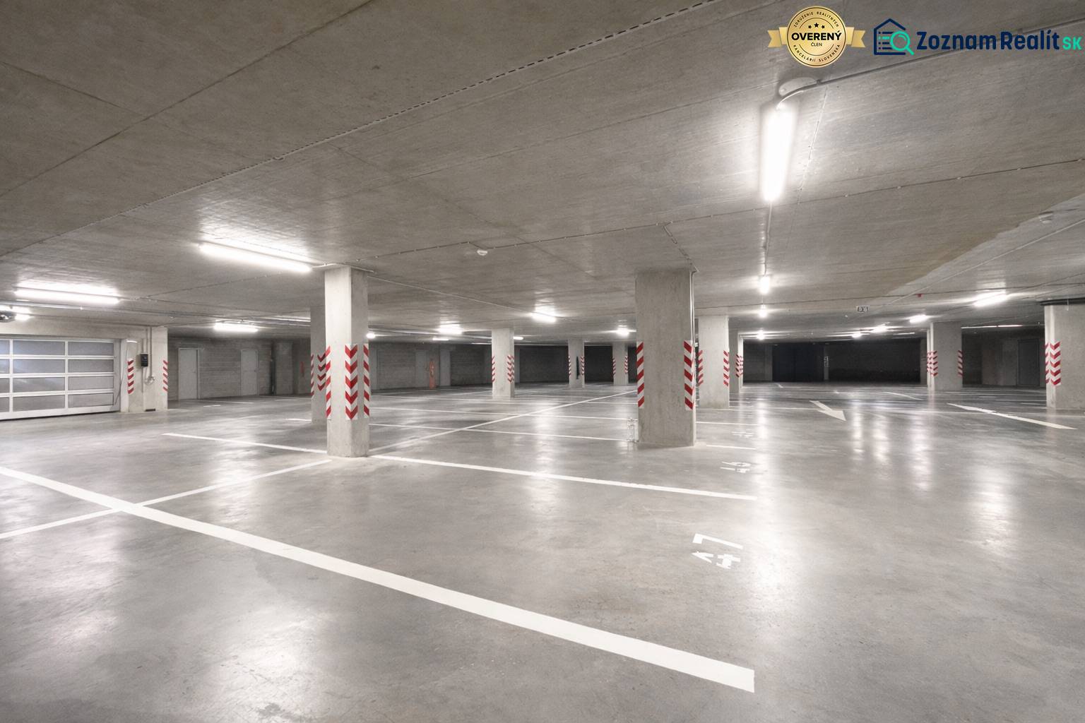 Spacious garages with marked parking spaces, bright lighting, concrete pillars.