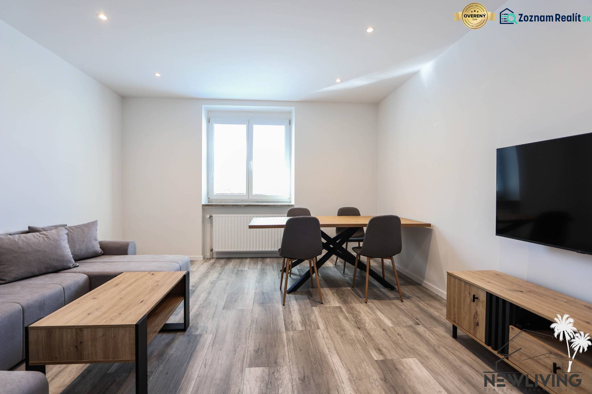Living room with wood-patterned flooring, a sofa, a dining table, and a television in a 3-room apartment.