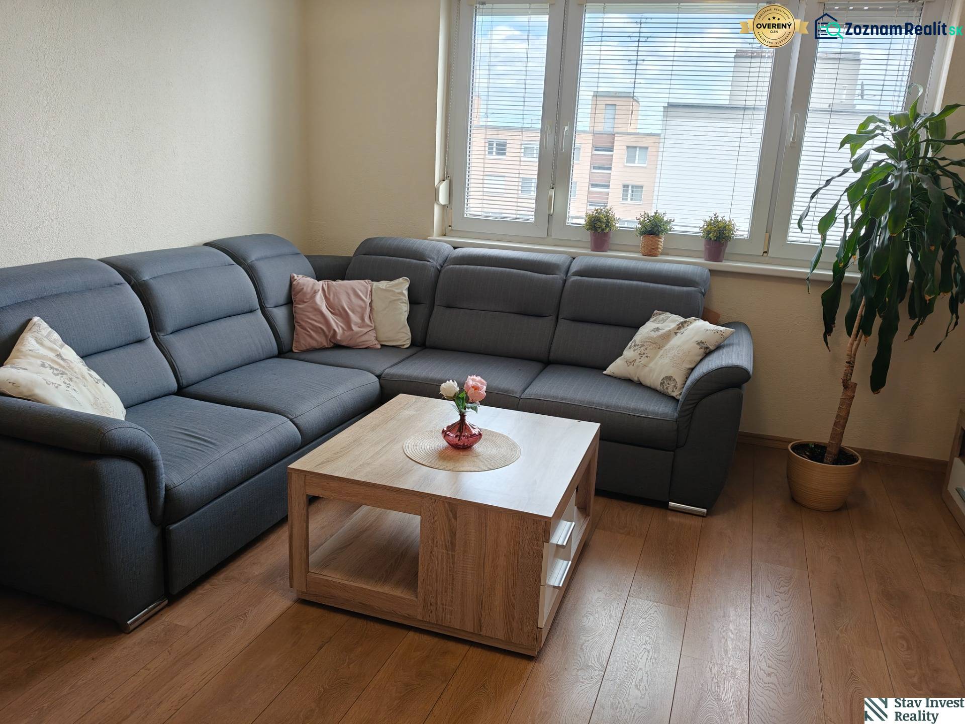 Living room in a 3-room apartment with a corner sofa and a wooden decor floor.
