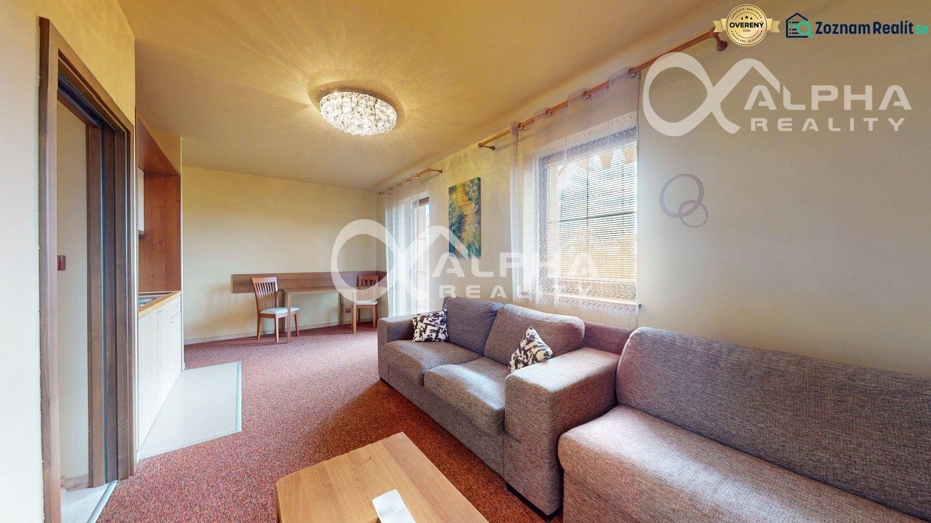 Living room in a two-room apartment with a sofa, dining table, and curtains.