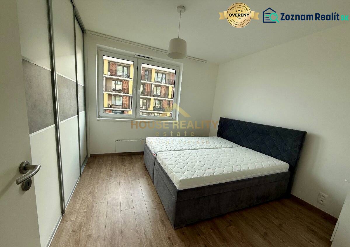 Bedroom with a built-in wardrobe, double bed, and wooden decor flooring in a two-room apartment.