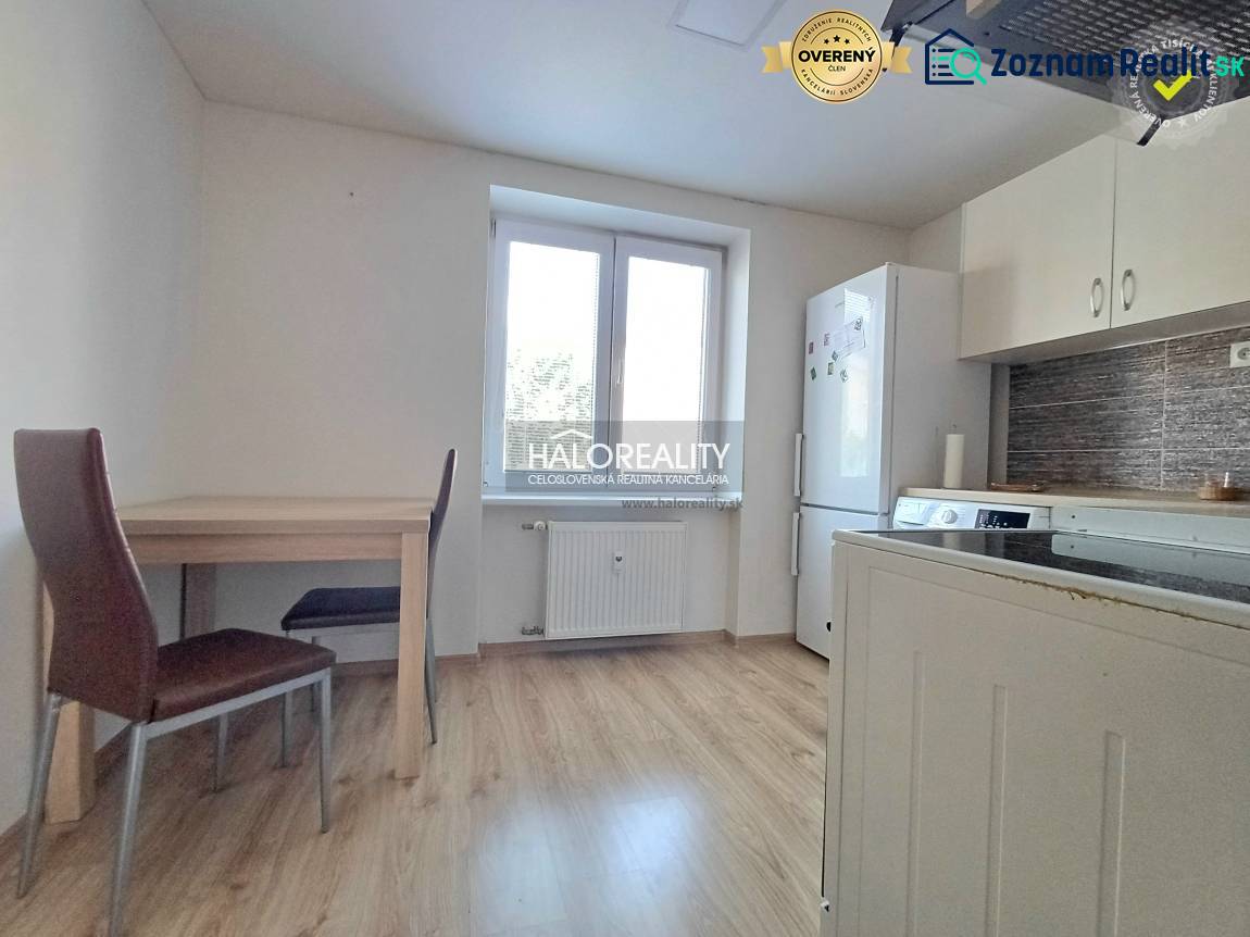 A kitchen in a studio apartment with furnishings and flooring featuring a wood decor.