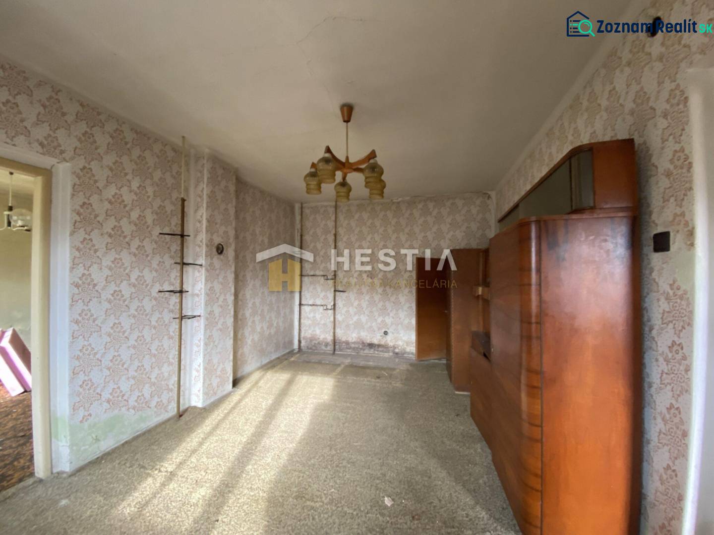 The interior of a family house with retro wallpapers and a wooden living room wall unit.