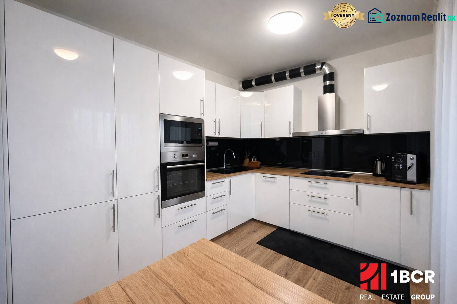 A kitchen in a 3-room apartment with white cabinets and a wood-patterned floor.