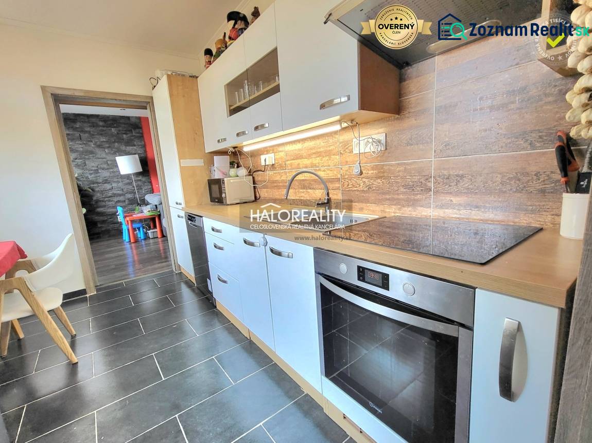 A kitchen in a 3-room apartment with light cabinets and a wood-patterned floor.