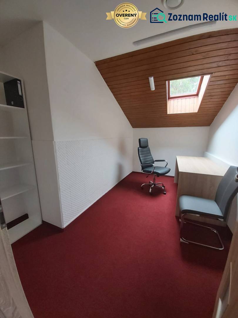 Offices with a red carpet and a ceiling window, a white wall, and wooden ceiling decor.