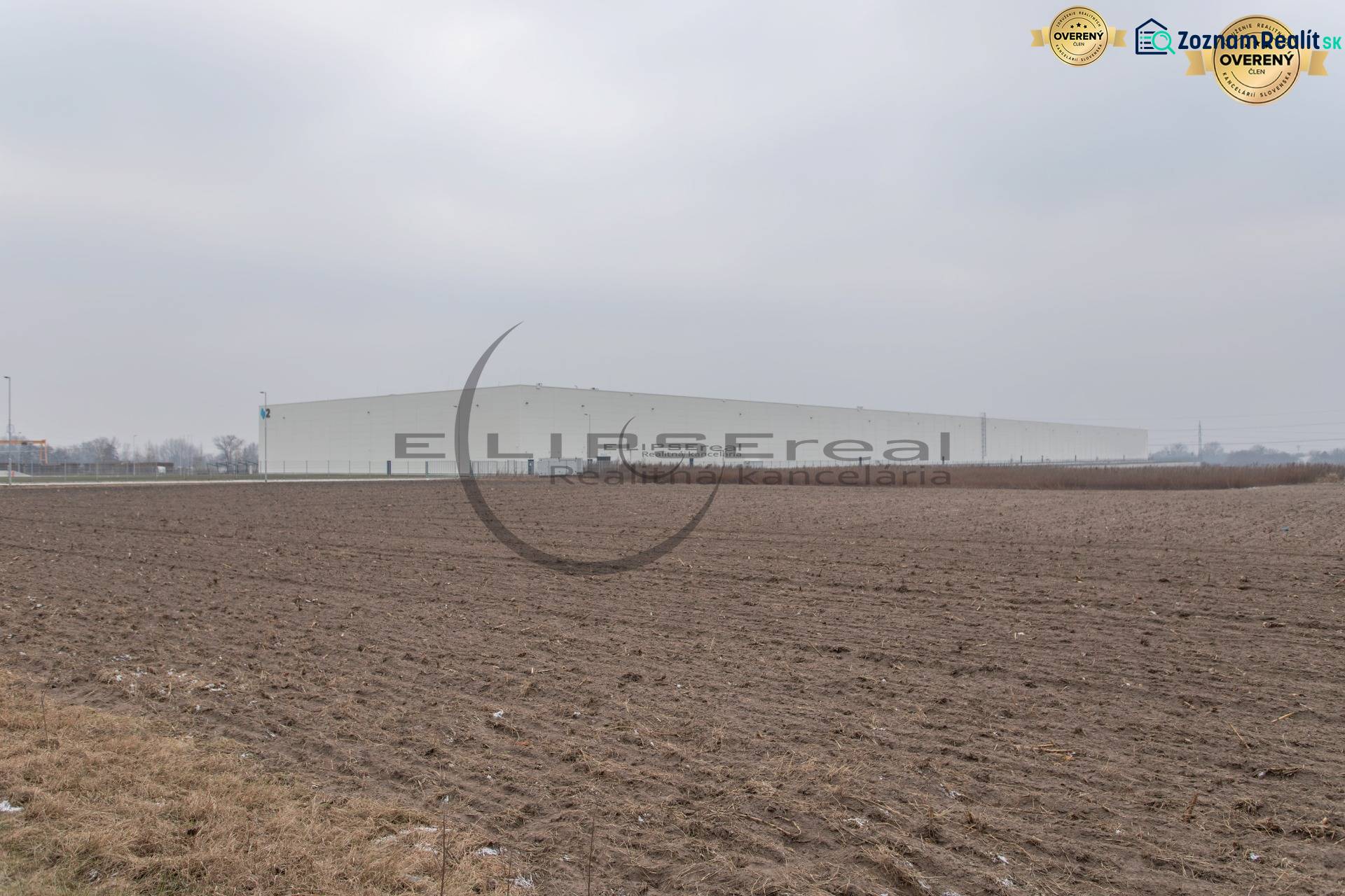 Industrial Street in Zohor, extensive commercial plots with a large building in the background.