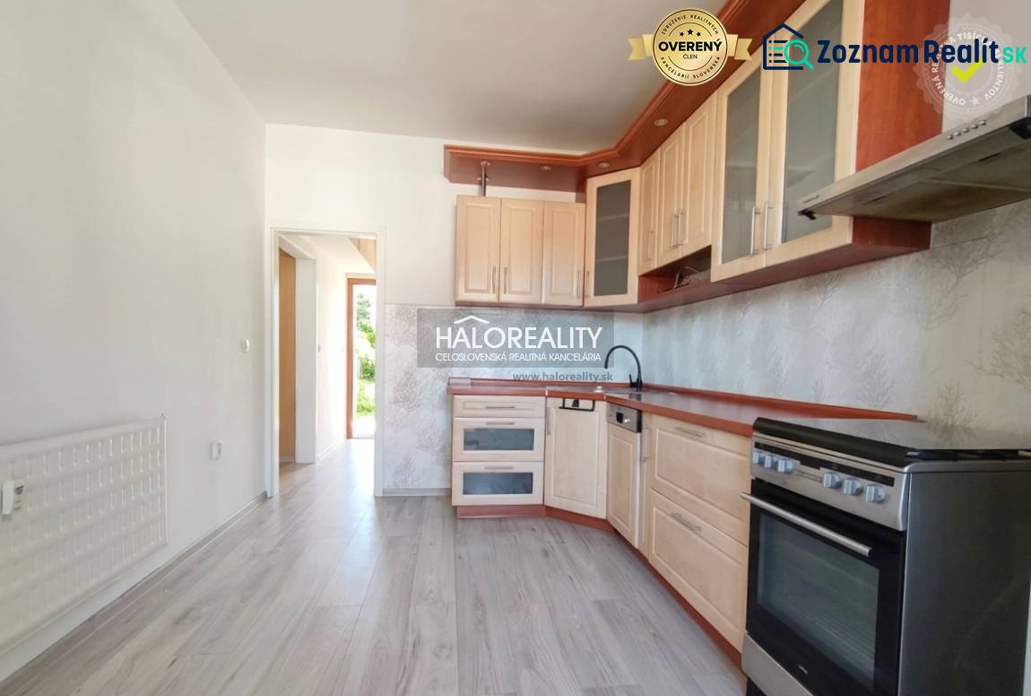 A kitchen in a 3-room apartment with a wooden decor floor and light furniture.