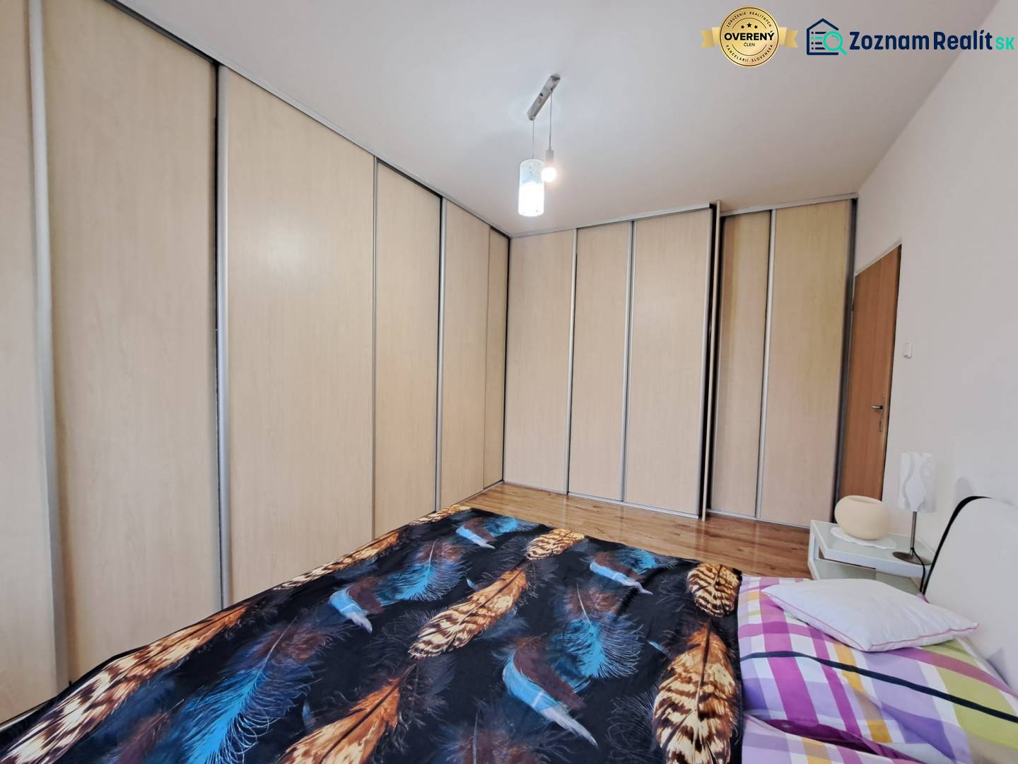 A bedroom with a large built-in wardrobe and a bed in a 2-room apartment.