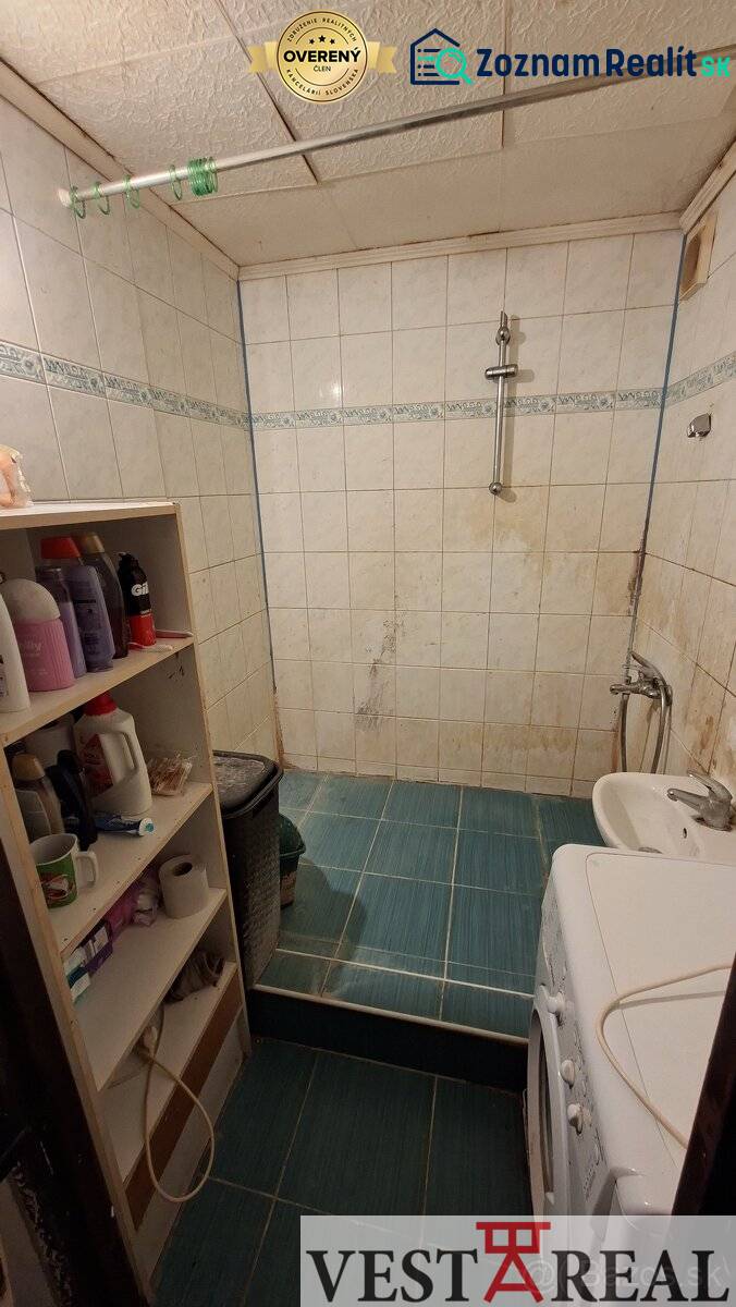 Bathroom in a 3-room apartment with a tiled floor and a washing machine.