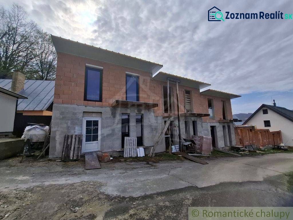 Unfinished cottage in Divín with a raw facade and glazed windows.