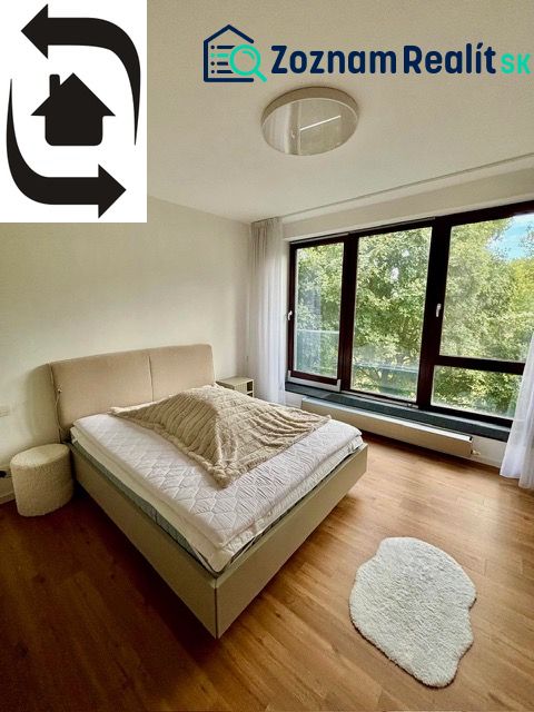 A bedroom with a light bed and a wooden decor floor in a 2-room apartment.