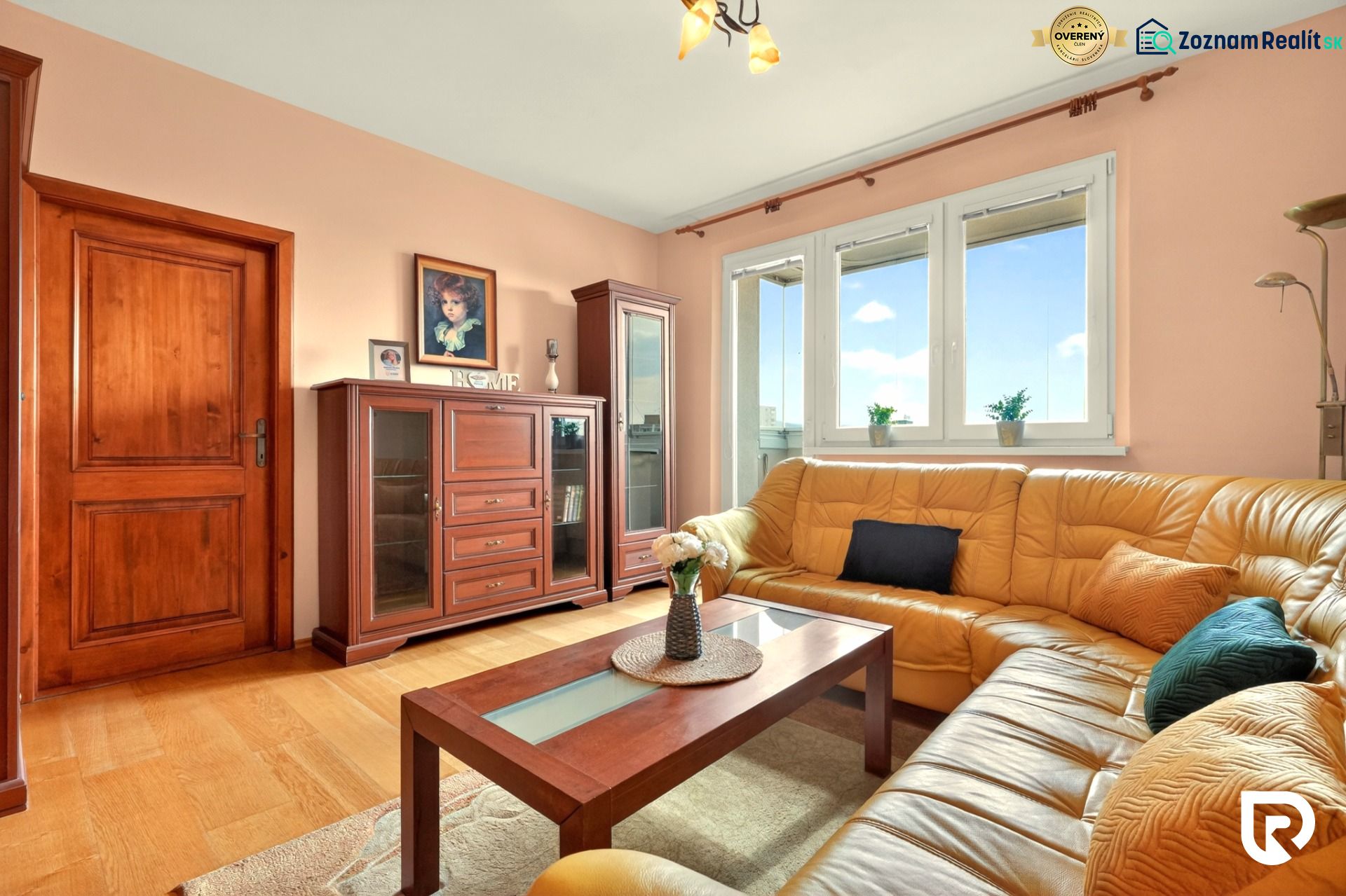 Living room in a three-room apartment with a wooden decor floor and a leather sofa.
