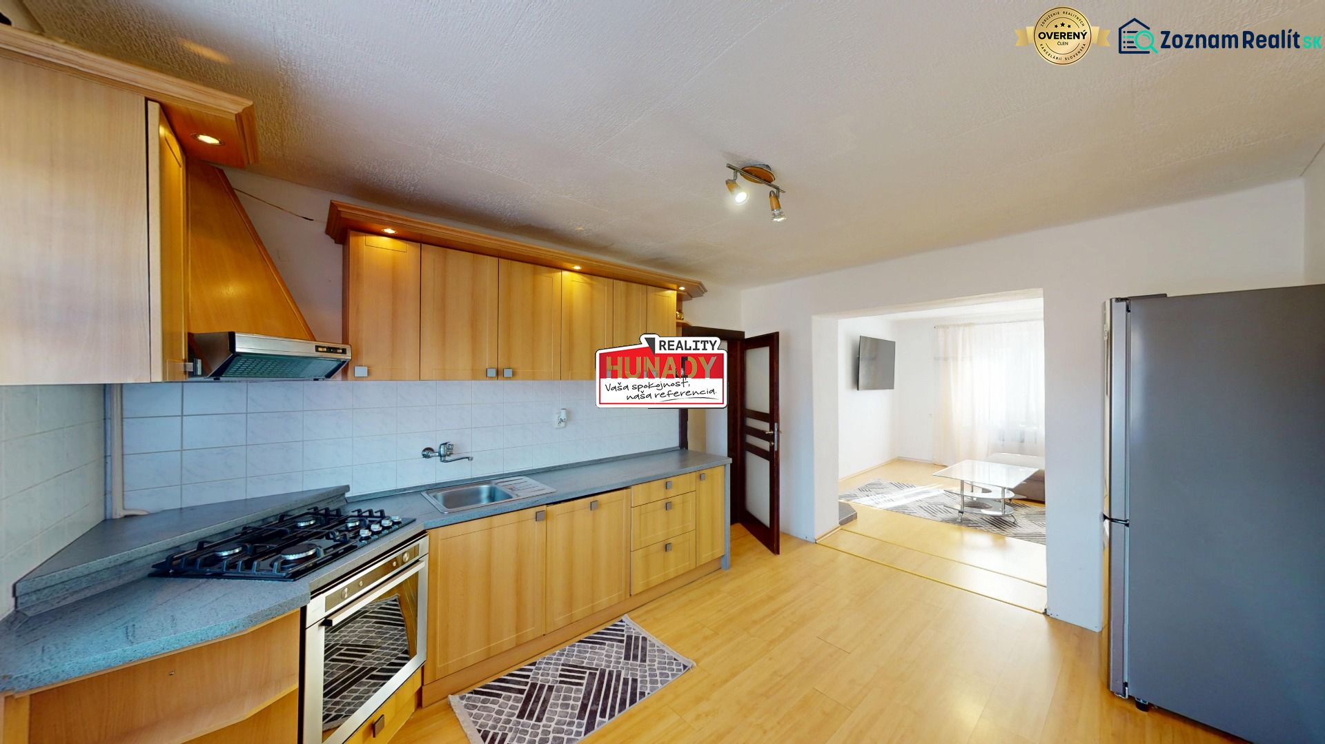 Two-room apartment with a kitchen, lighting fixtures, appliances, and flooring with a wood decor.