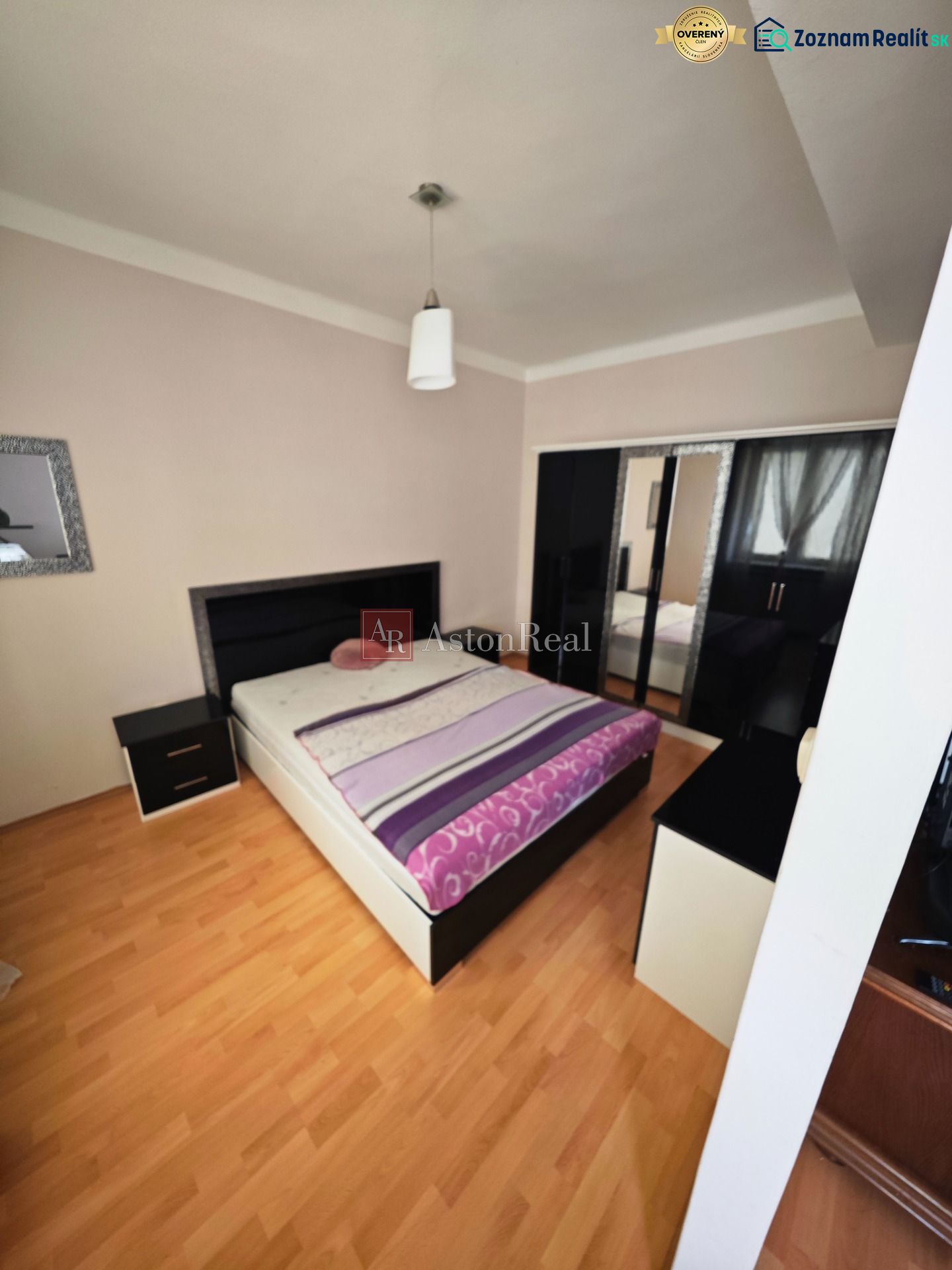 A bedroom with a bed, wardrobe, and wooden decor flooring in a two-room apartment.