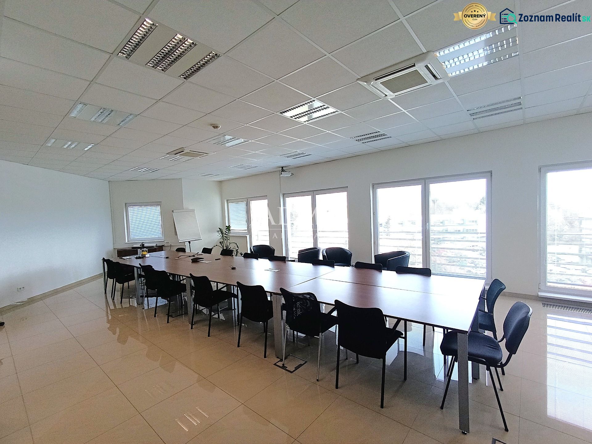 Spacious offices with a long table and many chairs, tiled floor.