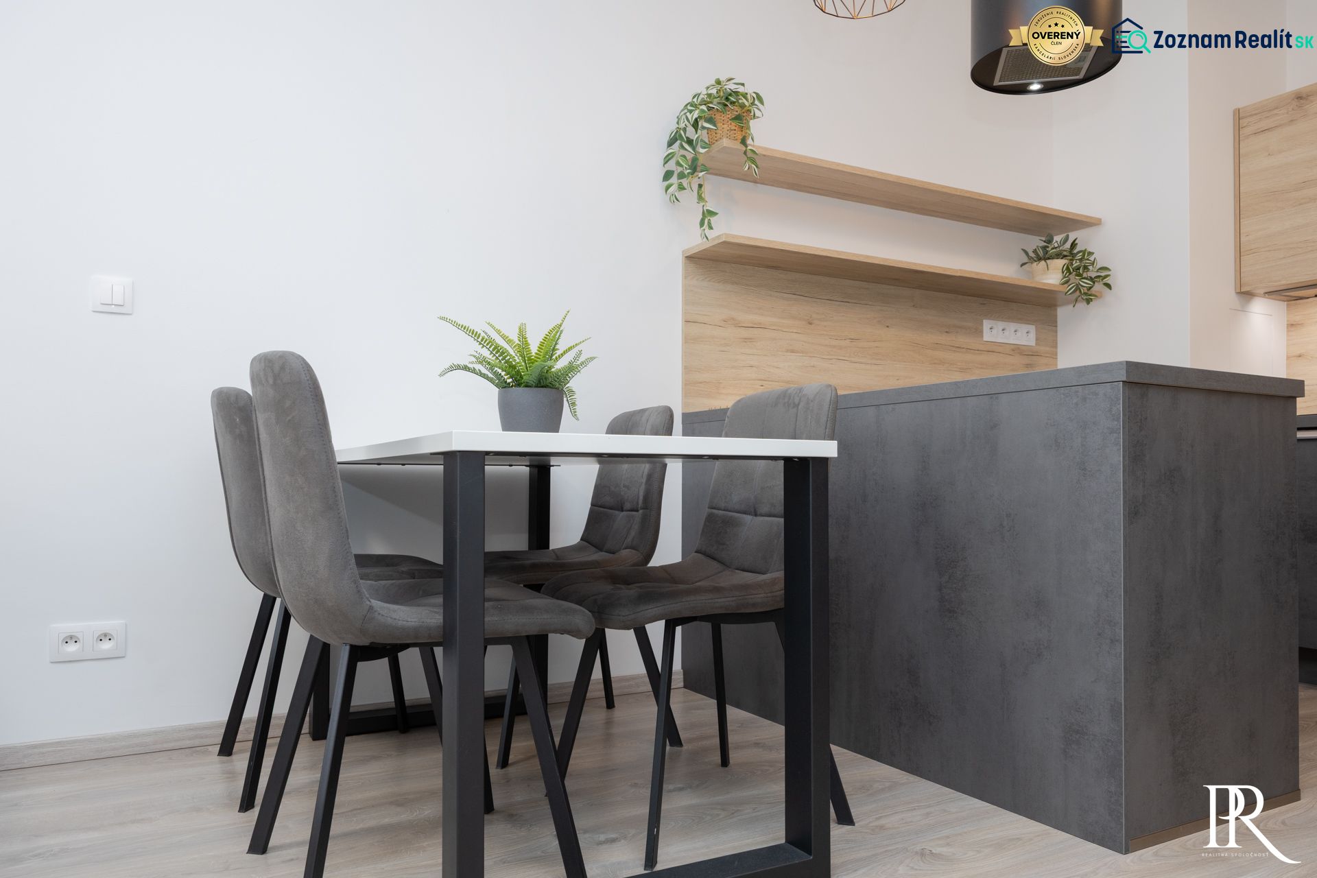 Dining furniture in a 2-room apartment with wood-patterned flooring and plants.