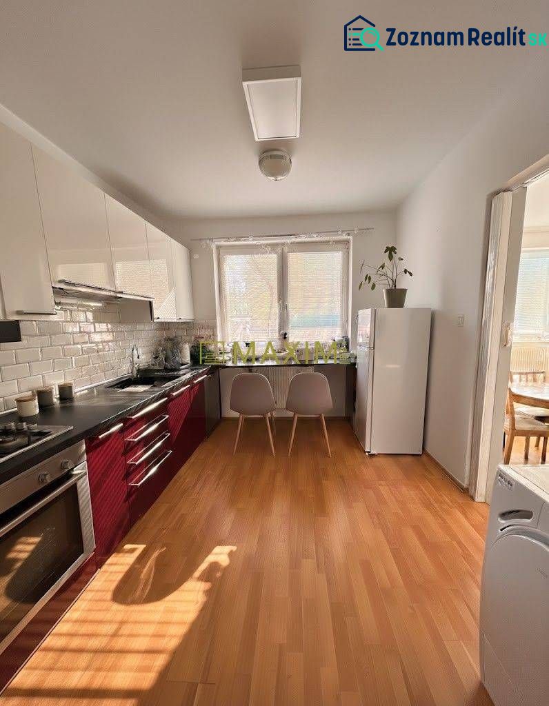 A kitchen with light cabinets, a floor with a wood decor in a 2-room apartment.