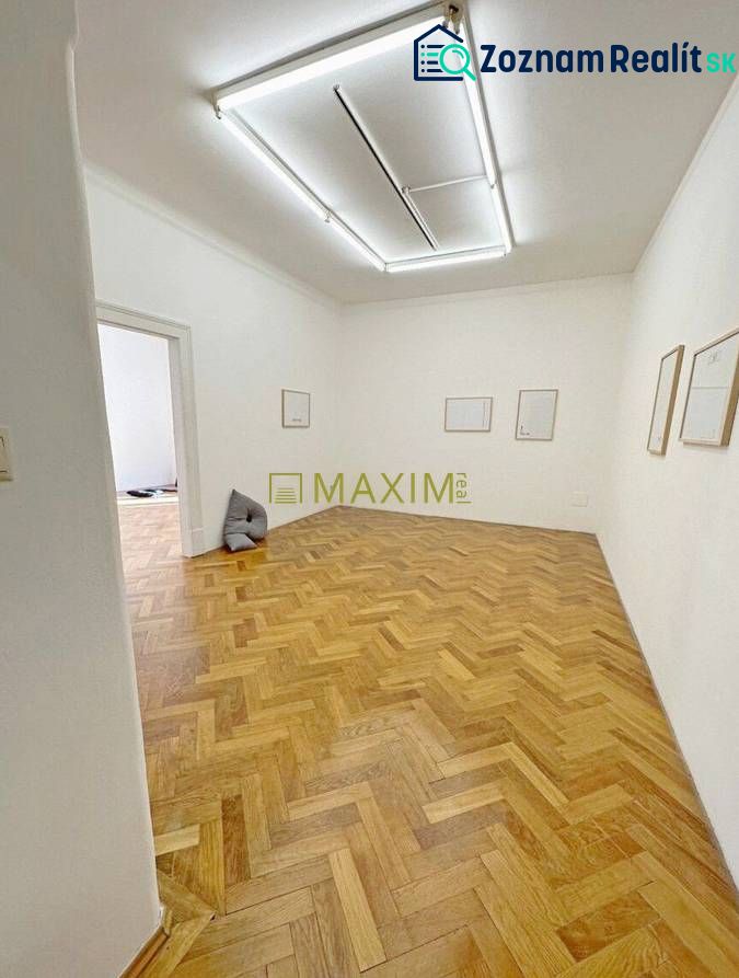 A room in a 3-room apartment with a wood-patterned floor and white walls.