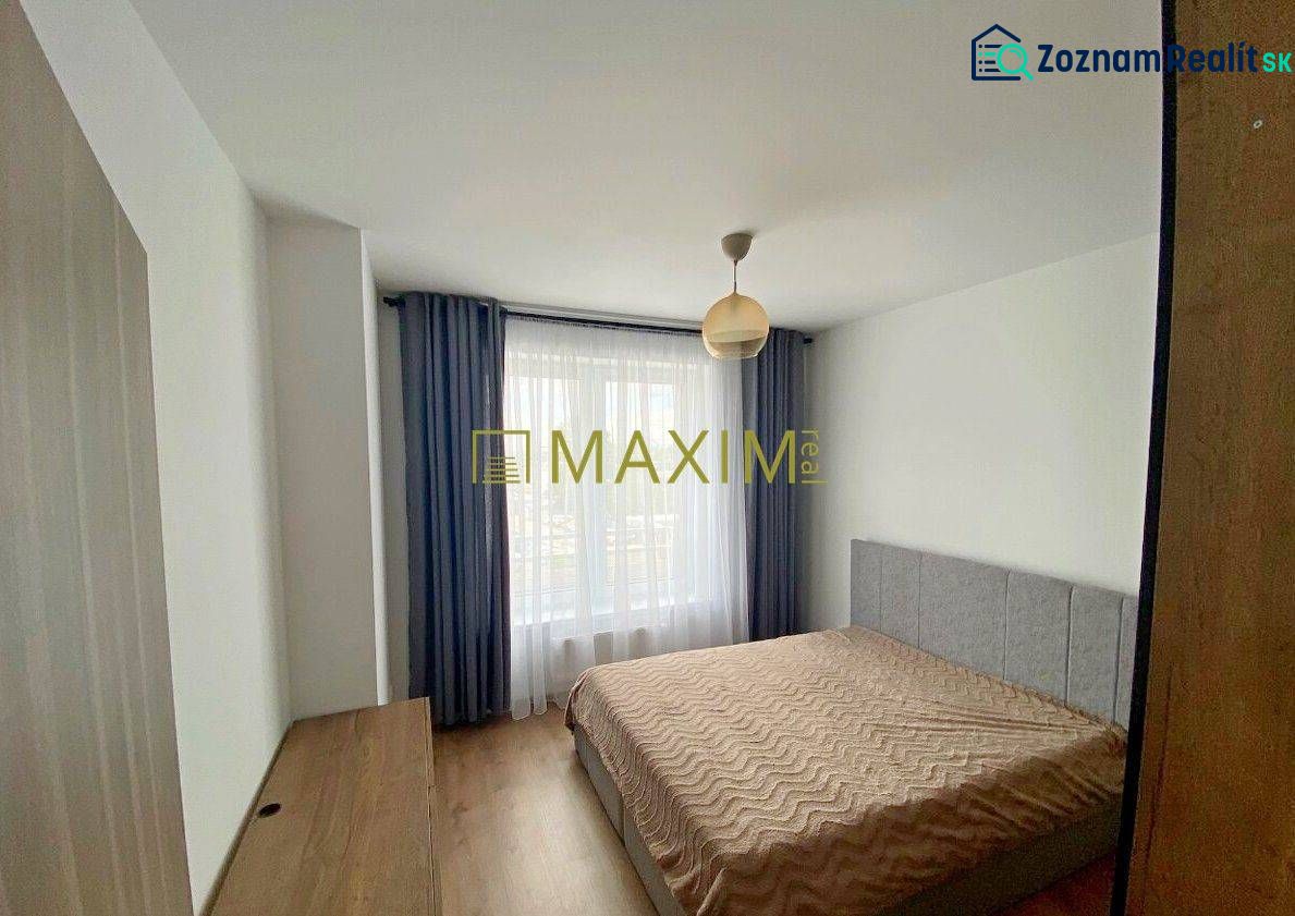 Bedroom in a 2-room apartment with a bed and a wooden decor floor.