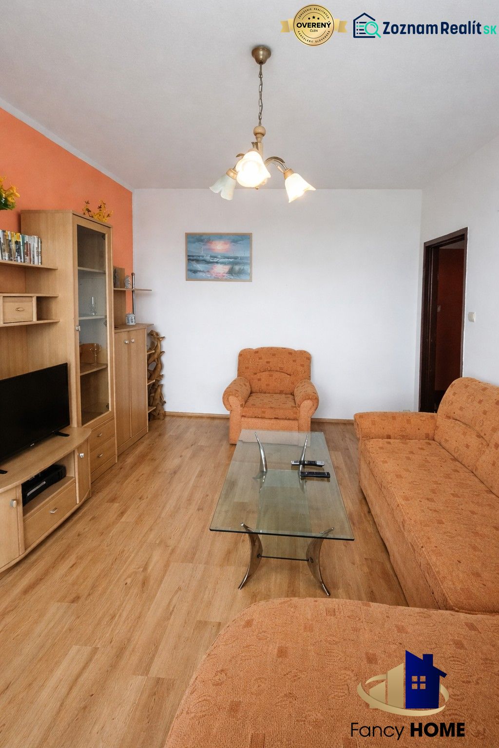Living room in a two-room apartment with a sofa, coffee table, and wooden decor flooring.