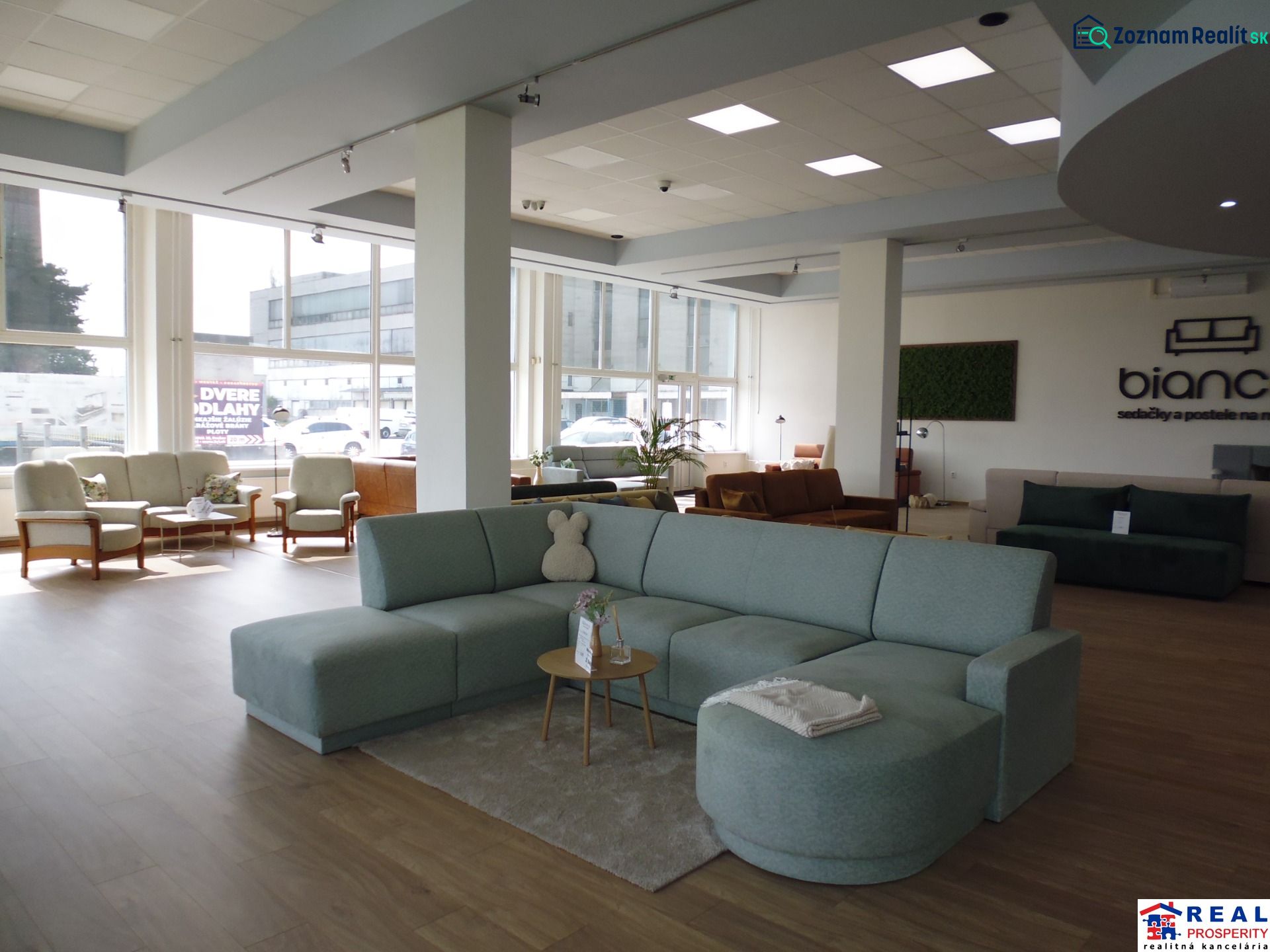 The commercial space offers a view of sofas and armchairs with a wooden decor floor.