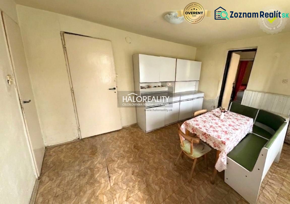 A dining room in a family house with a corner bench, a floor with a wooden decor, and cabinets.