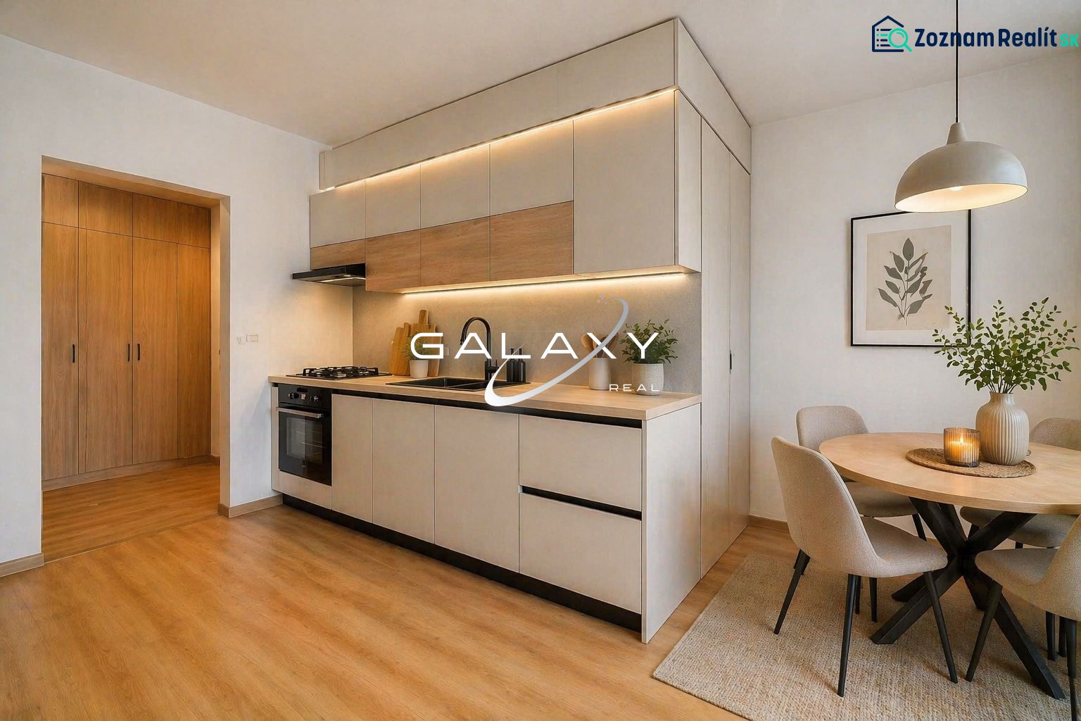 A kitchen in a 2-room apartment with a wooden decor floor, a dining table, and lights.