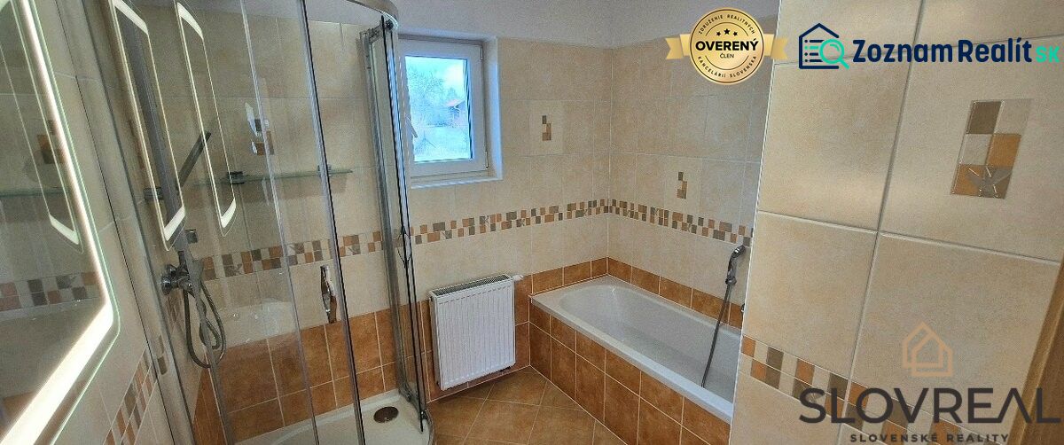 A bathroom with a corner shower and a bathtub in a family house.