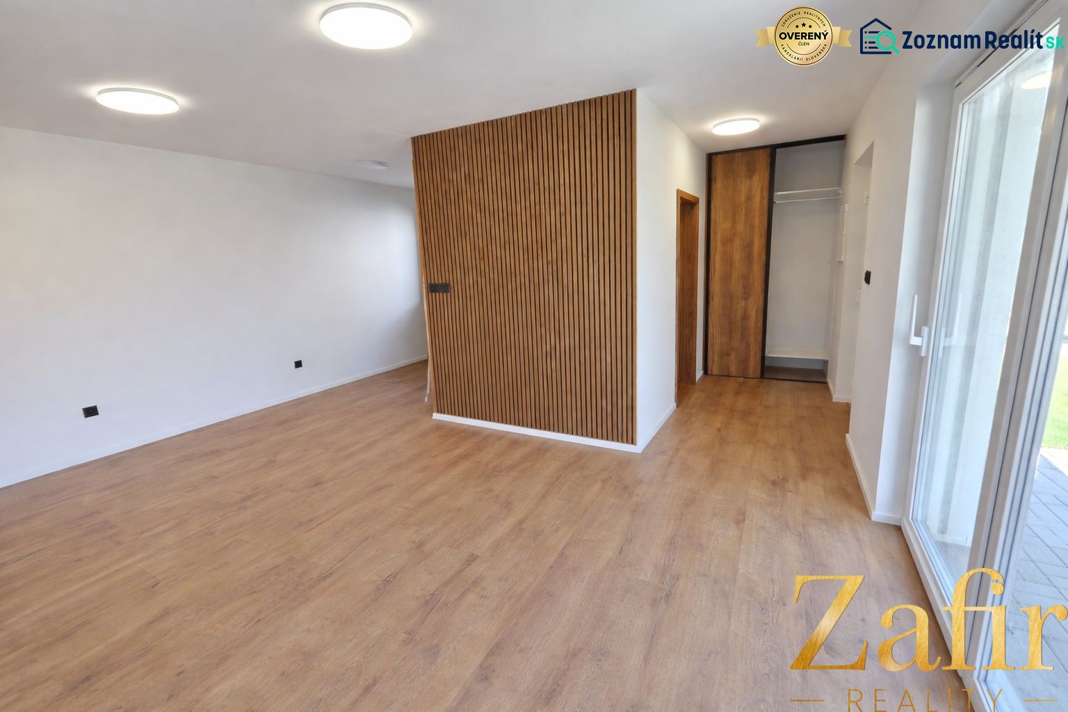 Interior of a family house with a wood-patterned floor and wooden details on the wall.