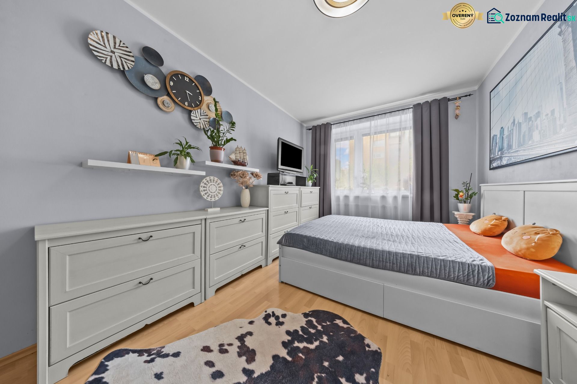 A bedroom in a 3-room apartment with a wooden decor floor and decorative elements.