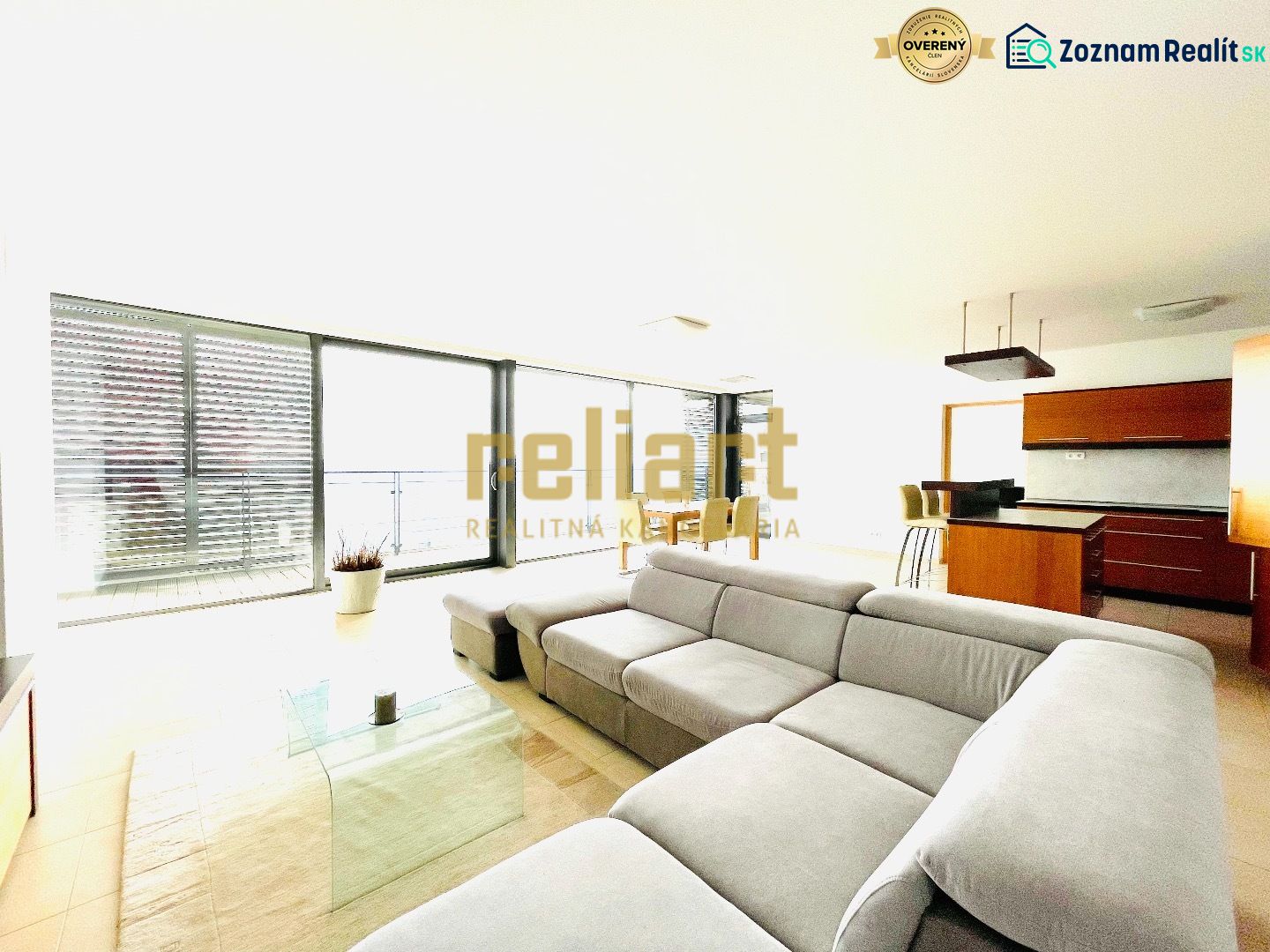 Living room in a 4-room apartment with a comfortable sofa and a kitchenette.