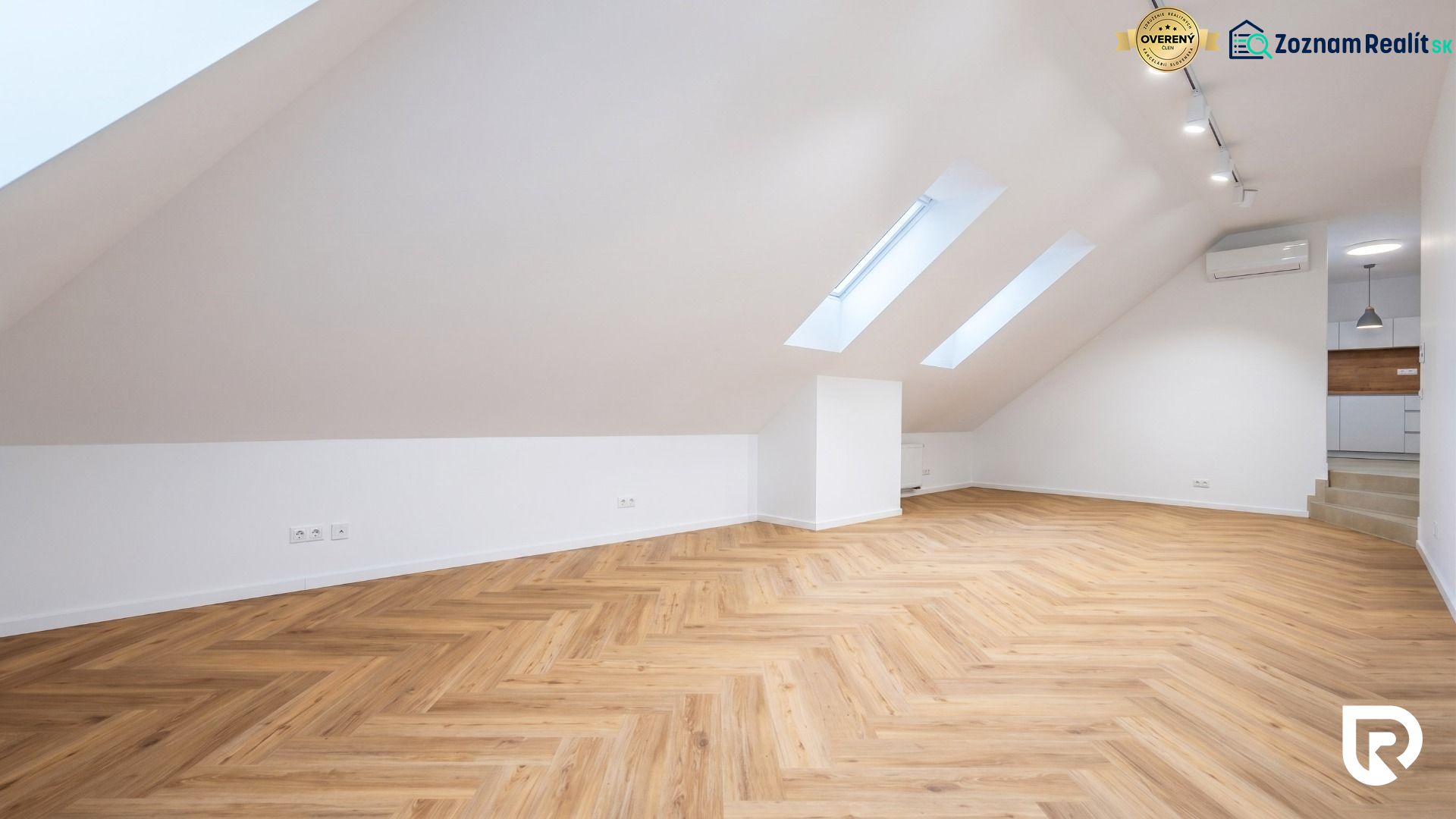 Attic space with a wooden decor floor and lighting suitable for offices.