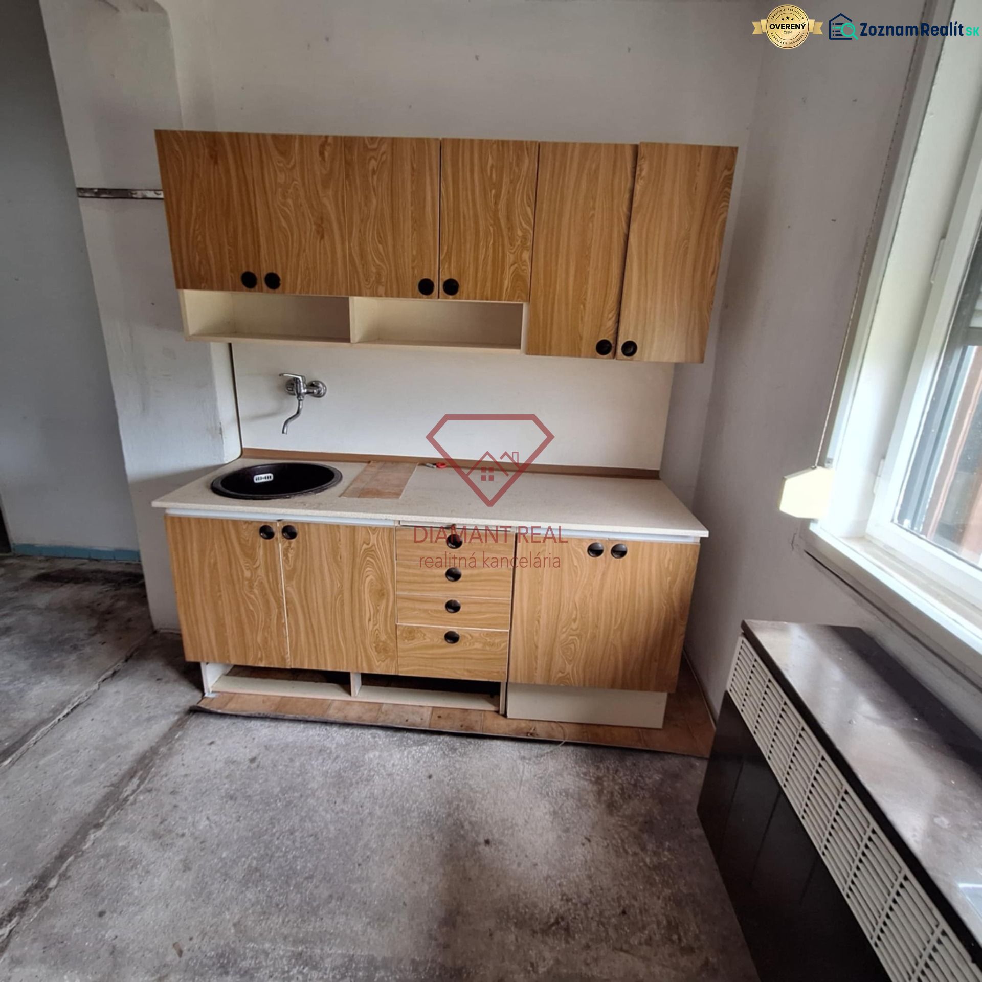 Wooden kitchen unit with a sink in the interior of a family house with low cabinets.