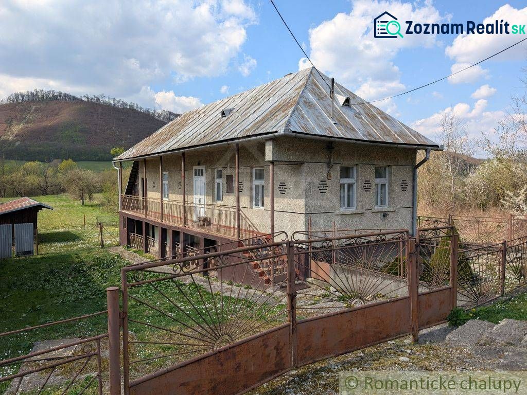A family house in Zubné with a metal roof, fencing, and a rural surrounding.