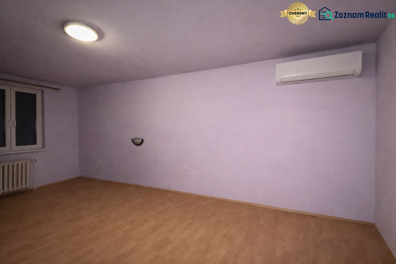 A room with air conditioning and a wooden decor floor in a family house.