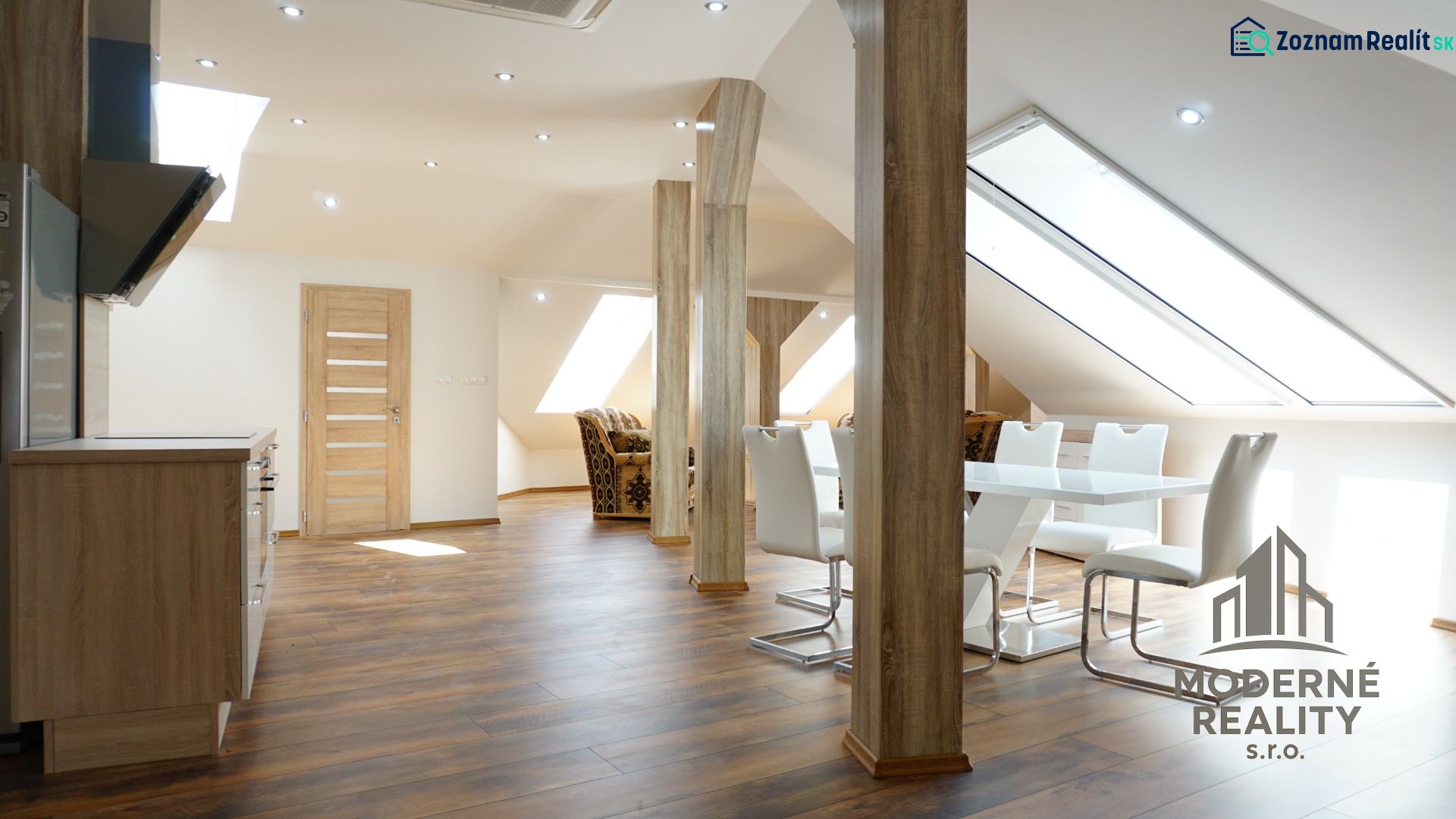 A bright interior of a 4-room apartment with a wooden decor floor and a dining table.