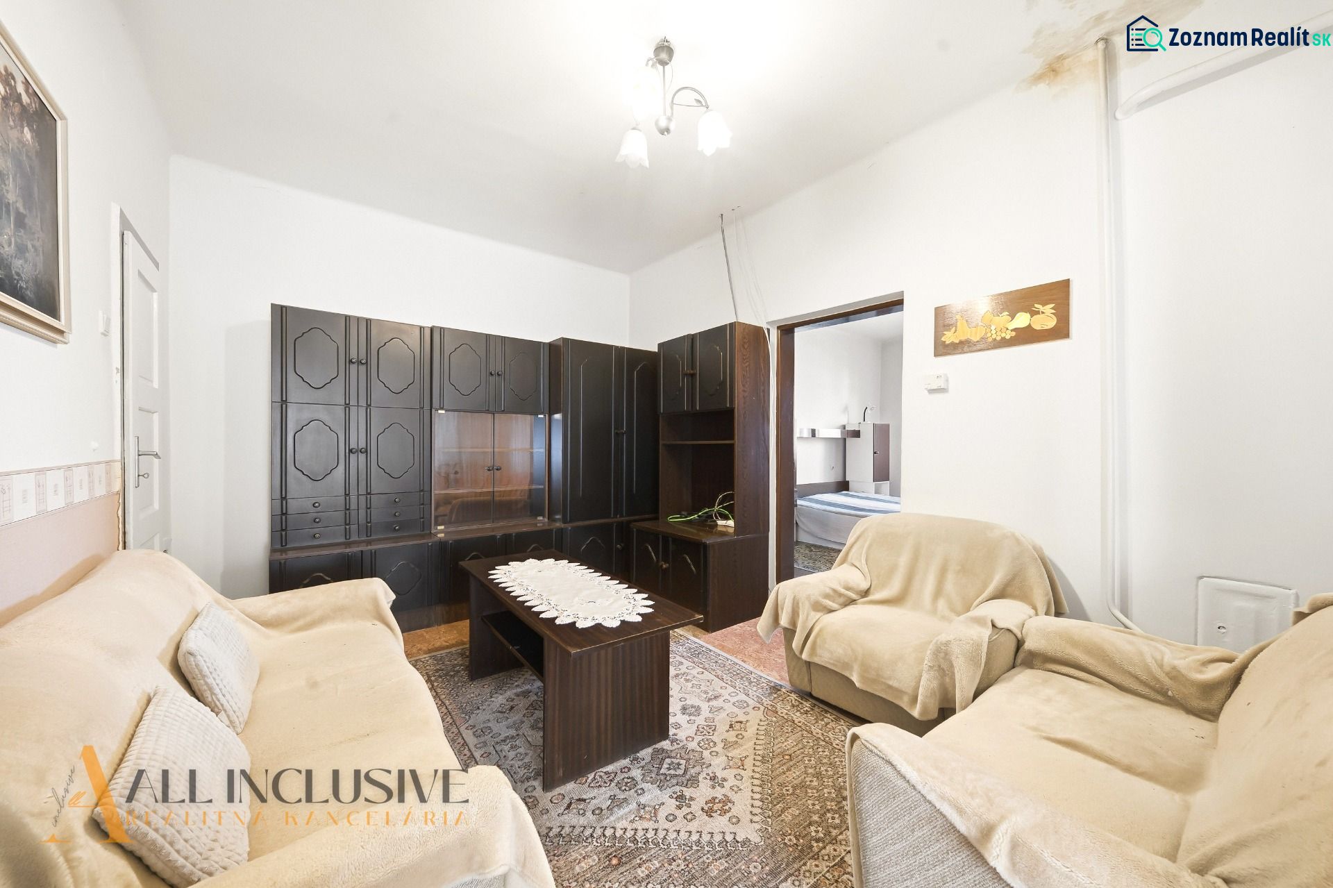 Living room with dark furniture and a floral carpet in a family house.