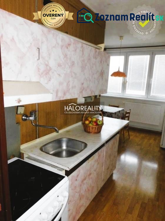 A kitchen with a built-in sink and a wooden decor floor in a 3-room apartment.
