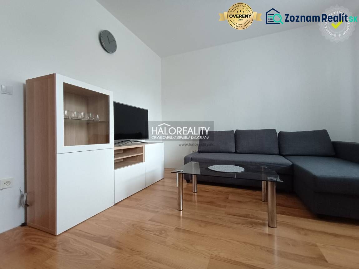 Living room in a two-room apartment with a wooden decor floor and a comfortable sofa.