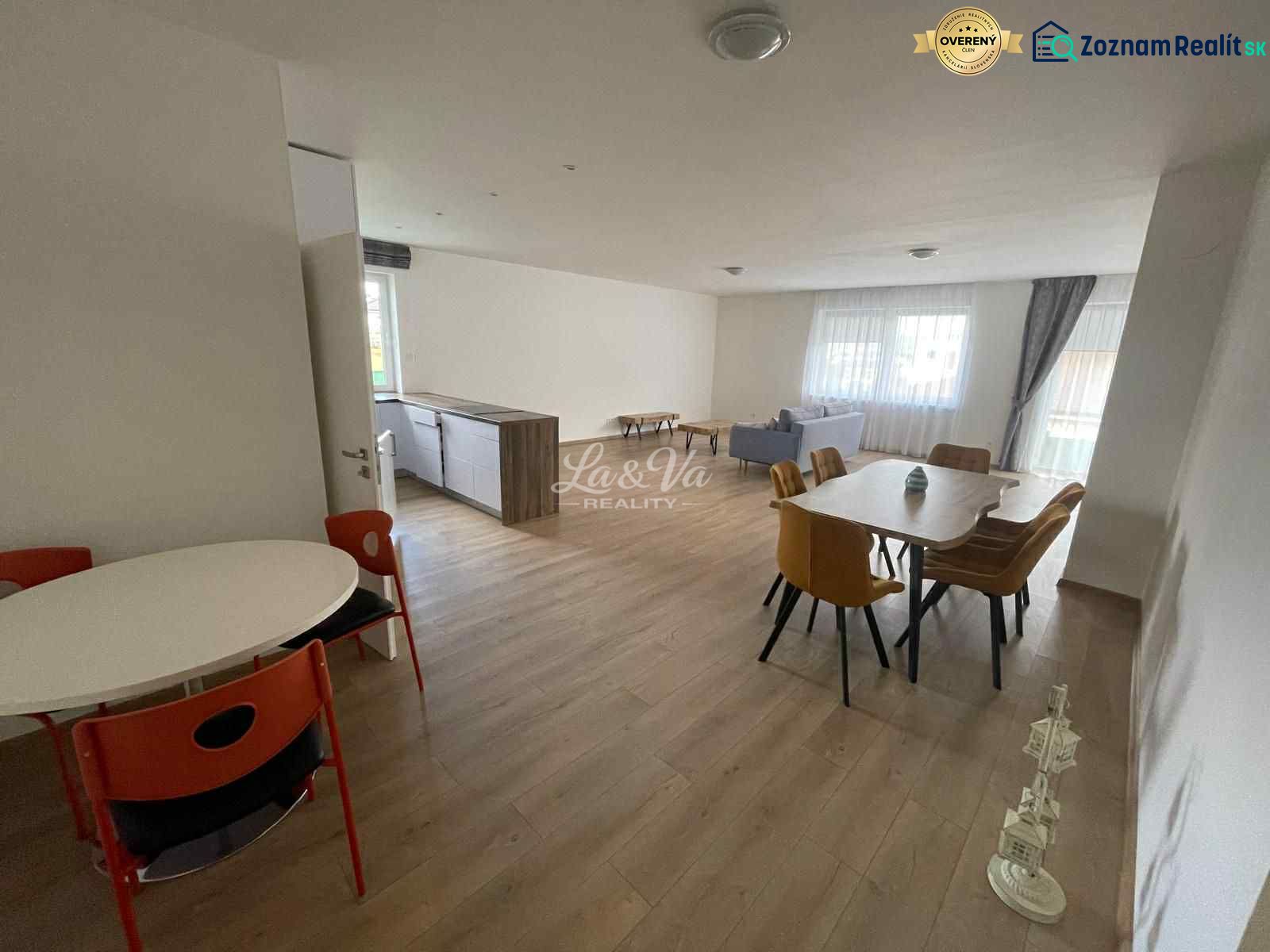 Spacious living room and dining area in a family house with wooden decor flooring.