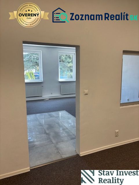 The interior of an office with carpet and tiles, pleasant light through the windows.
