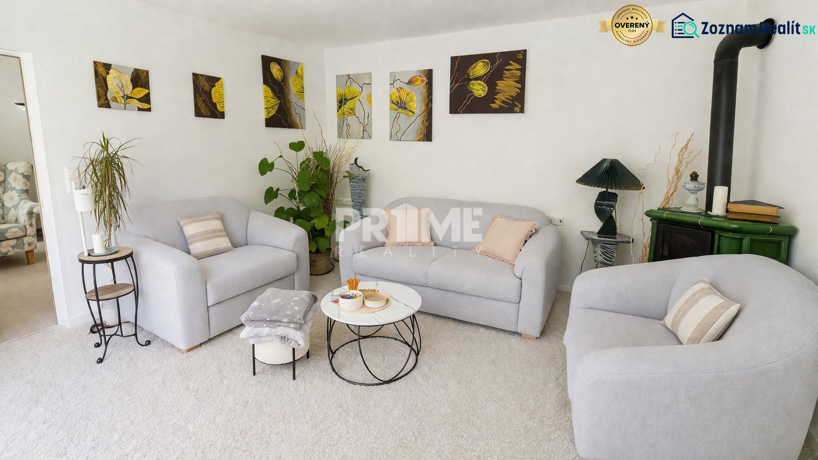 Living room in a family house with armchairs, a fireplace, and art paintings on the wall.