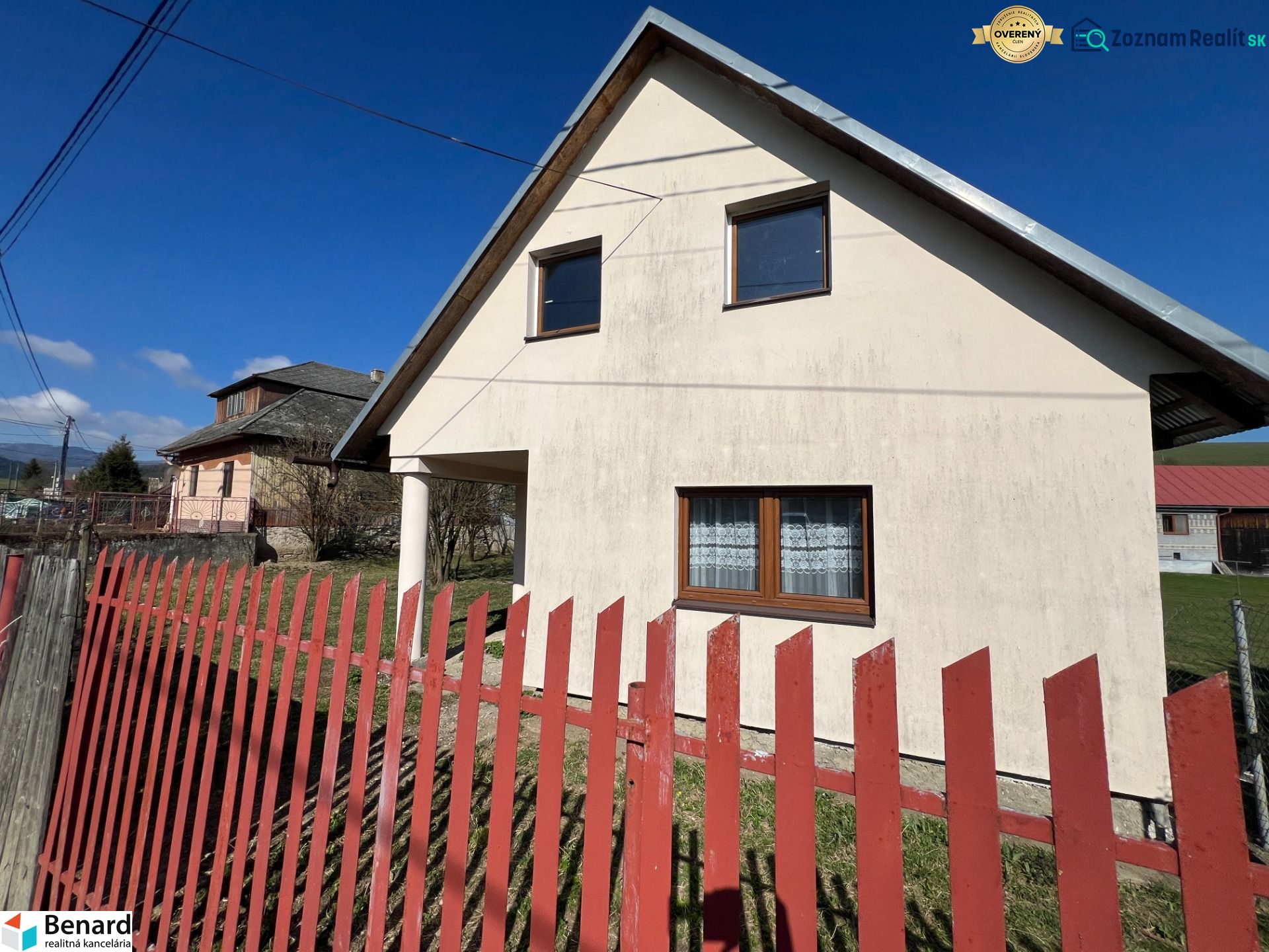 A family house in Vislanka with white plaster and a red fence.