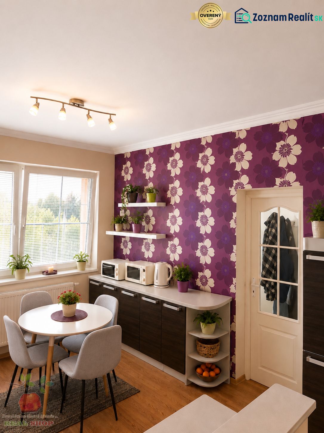 A kitchen in a 3-room apartment with purple wallpaper and a wooden decor floor.