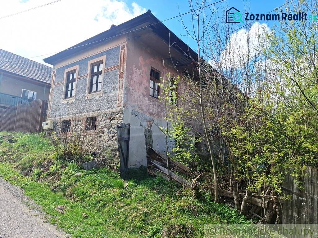 An old stone house in Heľpa, unique property, with a neglected facade and natural surroundings.